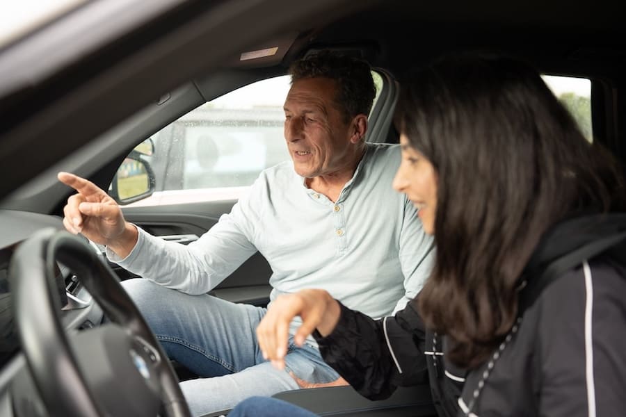 Jürgen Wagner gibt einer Fahrschülerin im Auto Hinweise